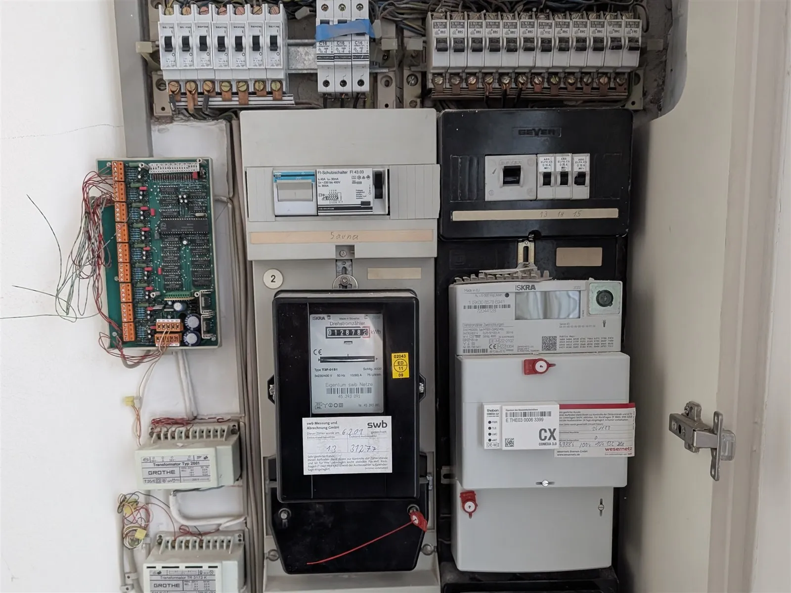 Älterer Zählerplatz mit Sicherungsautomaten, altem Drehstromzähler und neuem digitalen Zähler