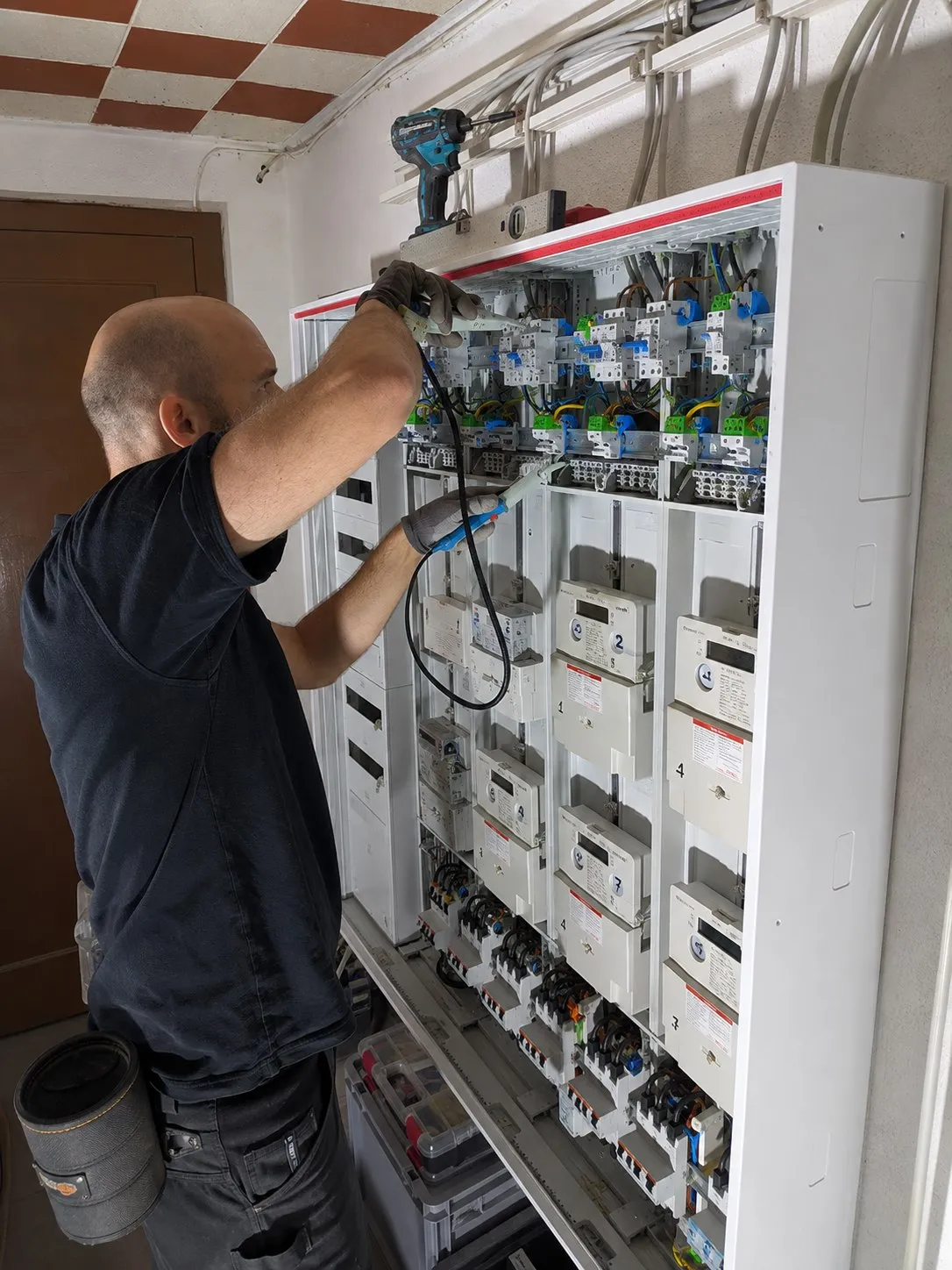 Elektriker misst die Schutzmaßnahmen am fertig verdrahteten Zählerschrank